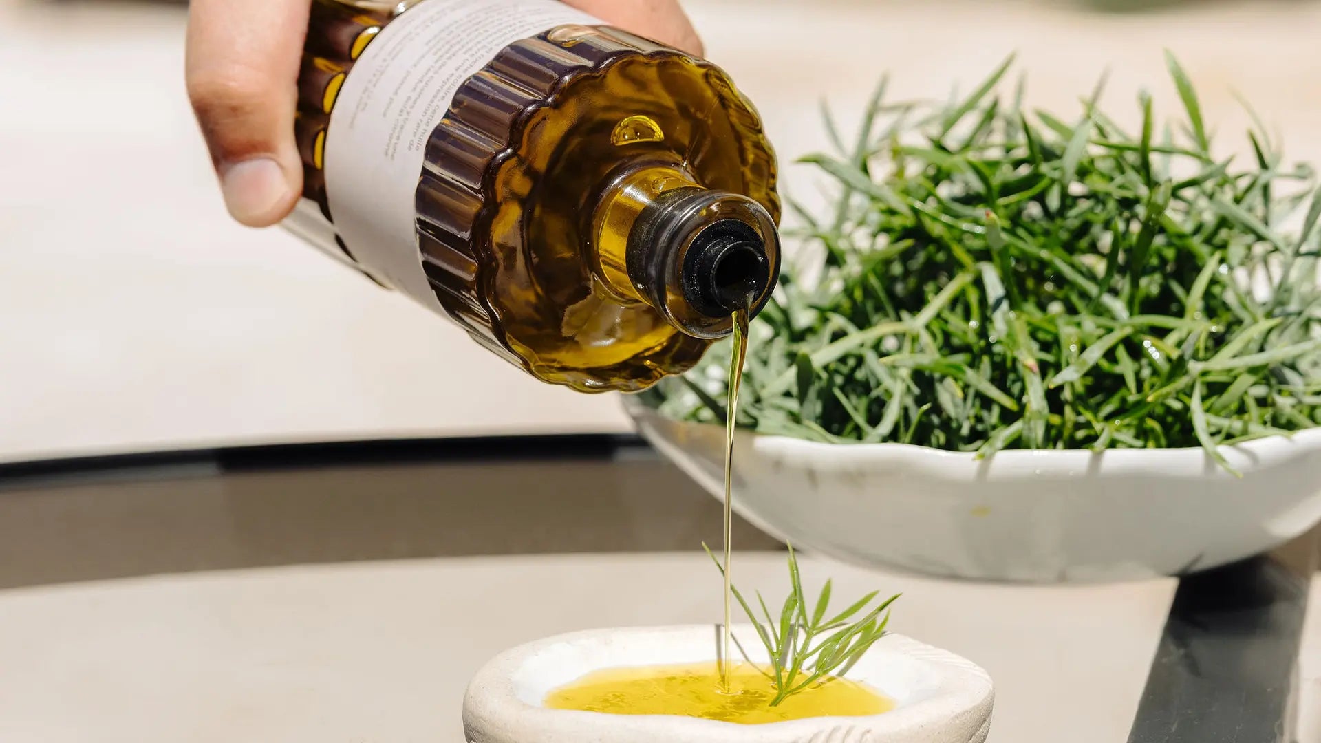 Versée d'huile d'olive parfumée à la criste marine sur une préparation culinaire fraîche