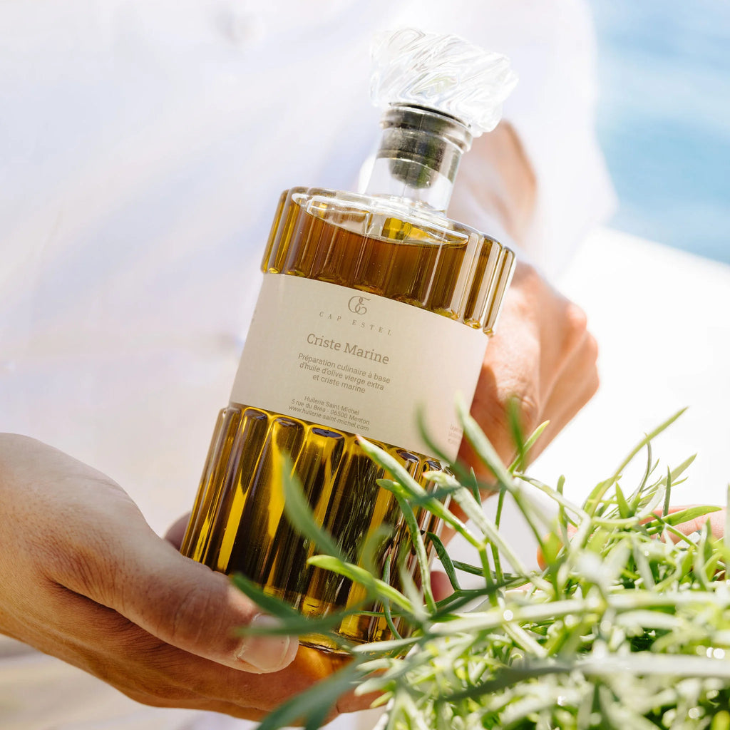 Huile d'olive à la Criste Marine Huilerie Saint-Michel et Cap Estel, Bouteille 500ml en mains